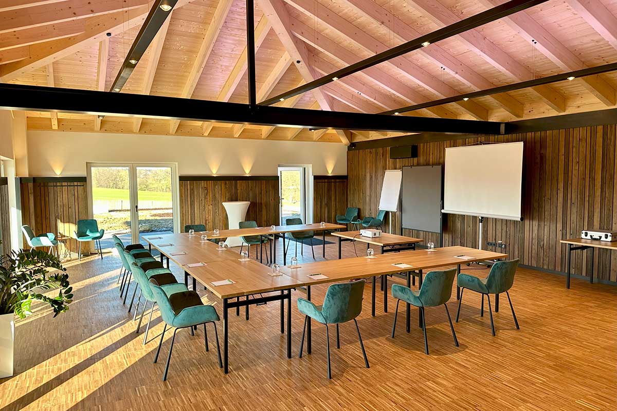 Moderner Tagungsraum im Bungalow des Landhotel Hallnberg bei München mit U-Form-Bestuhlung, Holzboden und Beamer