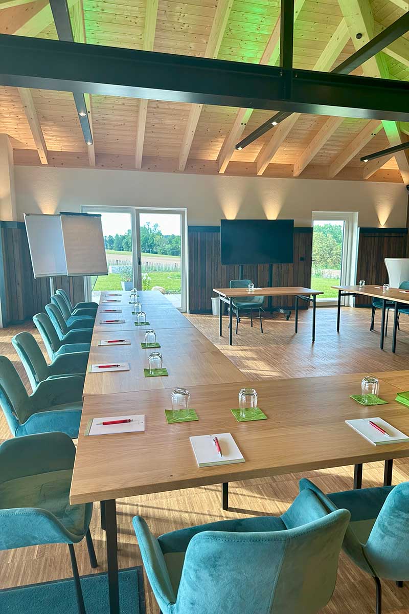 Tagungsraum im Bungalow des Landhotel Hallnberg bei München mit U-Form-Bestuhlung und Gartenzugang.